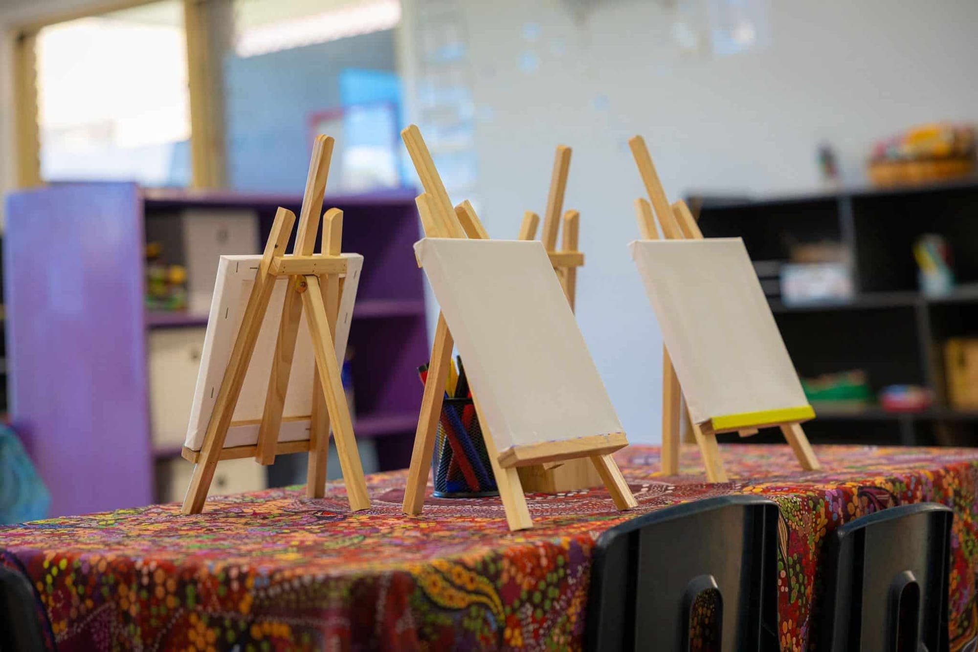 Three small easels with blank canvases ready for painting